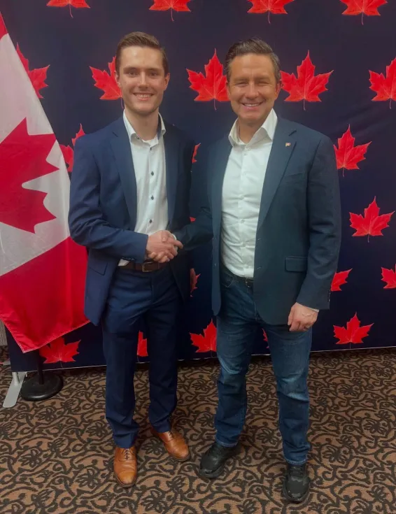 Matt MacFarlane with Conservative Leader Pierre Poilievre shaking hands in front of Canadian flag background